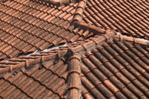 Weathered clay roof tiles showing potential roofing defects buyers should look for during a home inspection.