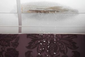 Water leaking through a damaged ceiling, illustrating a common plumbing-related red flag found during home inspections.