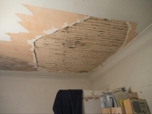 Water-damaged ceiling with peeling plaster, a common plumbing-related concern noted during home inspections.